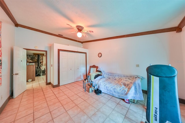 bedroom featuring crown molding, ceiling fan, a closet, and a textured ceiling