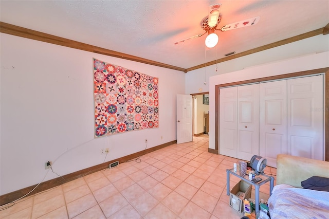 bedroom with crown molding, a textured ceiling, ceiling fan, and a closet