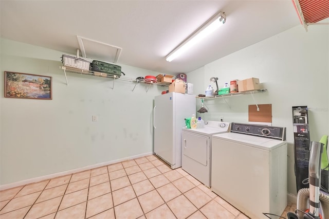 washroom featuring light tile patterned floors and washer and dryer