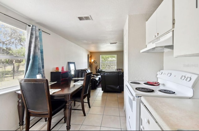 kitchen featuring electric stove, white cabinetry, and light tile patterned flooring