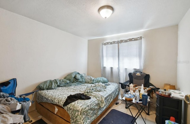 bedroom featuring tile patterned flooring and a textured ceiling