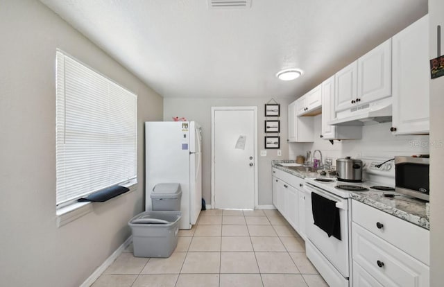 kitchen featuring light stone countertops, sink, white cabinets, white appliances, and light tile patterned floors