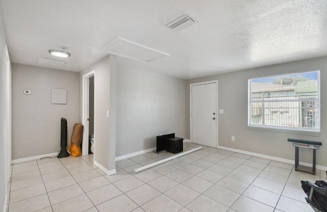 entryway with light tile patterned floors and a textured ceiling