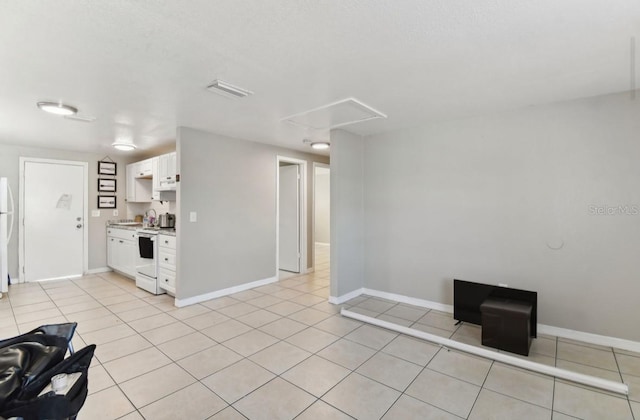 interior space with light tile patterned floors, white cabinets, and white appliances