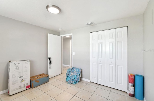 tiled bedroom featuring a closet