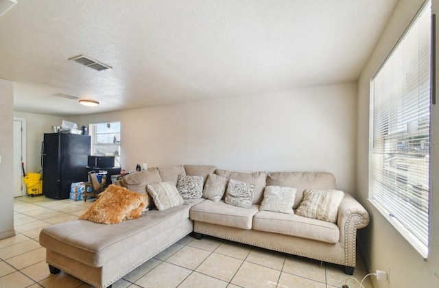 living room featuring light tile patterned floors and a textured ceiling