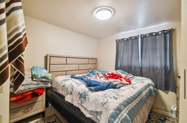 tiled bedroom featuring a textured ceiling