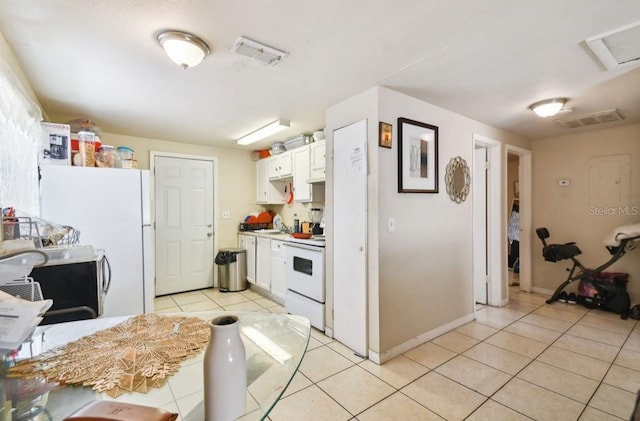 kitchen with light tile patterned floors, white cabinets, white appliances, and sink