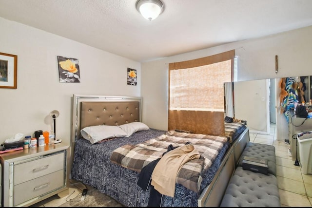 bedroom with light tile patterned floors and a textured ceiling