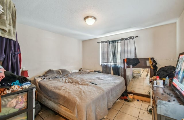 bedroom featuring light tile patterned floors and a textured ceiling