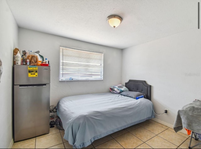 bedroom featuring stainless steel fridge and light tile patterned floors