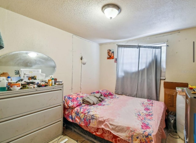 bedroom featuring a textured ceiling and light tile patterned flooring