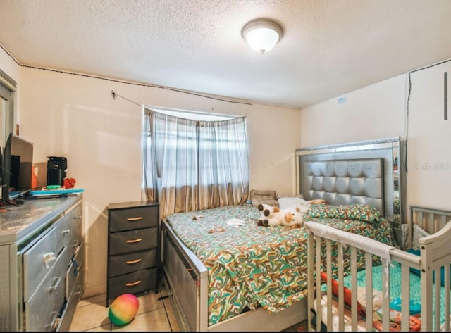 bedroom with light tile patterned floors and a textured ceiling