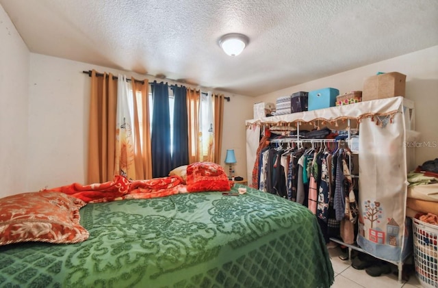 tiled bedroom with a closet and a textured ceiling