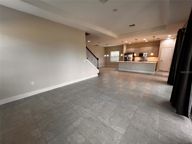 unfurnished living room with a tray ceiling