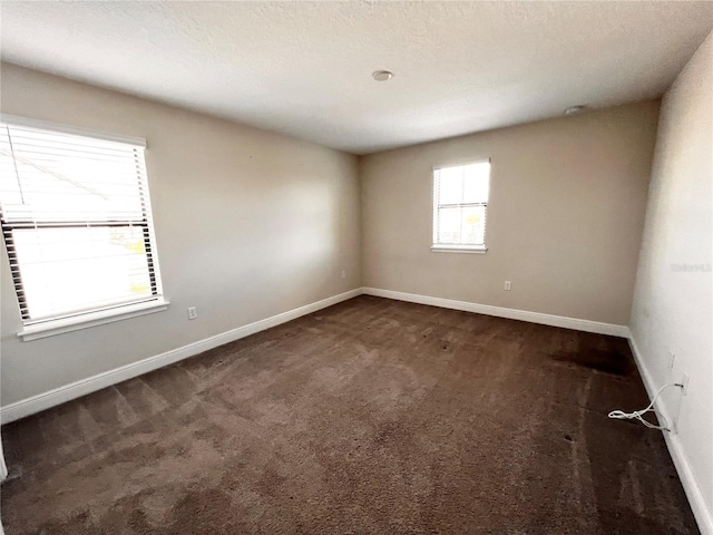 carpeted empty room with a textured ceiling