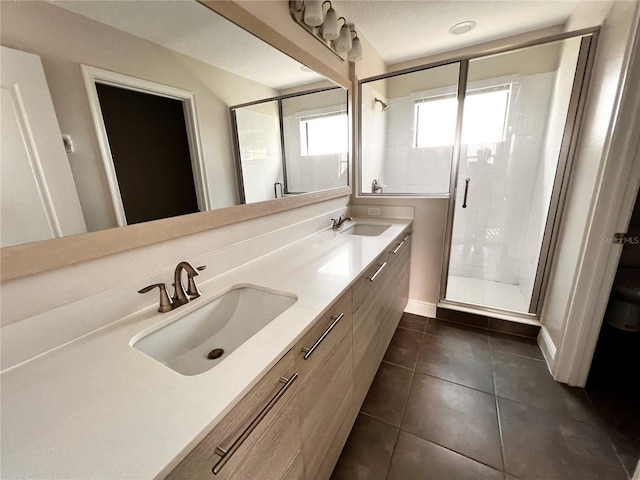 bathroom featuring a shower with door, vanity, and tile patterned flooring