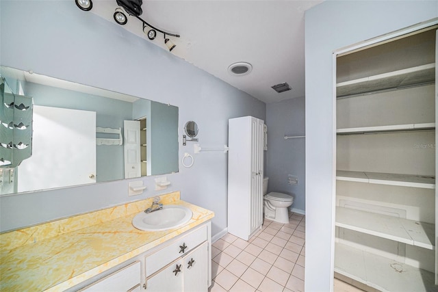 bathroom featuring tile patterned flooring, toilet, and vanity