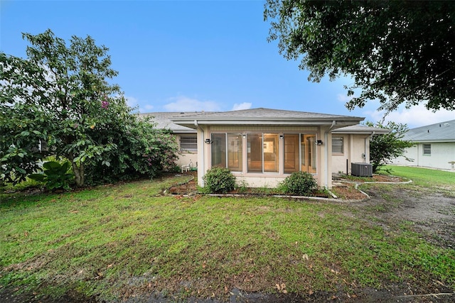 single story home featuring central AC unit and a front lawn