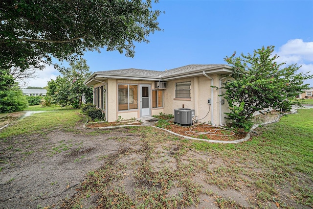 view of front of house with central AC unit and a front yard