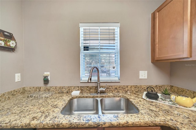 kitchen featuring light stone countertops and sink