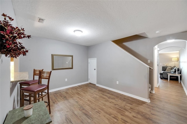 living area with wood-type flooring and a textured ceiling