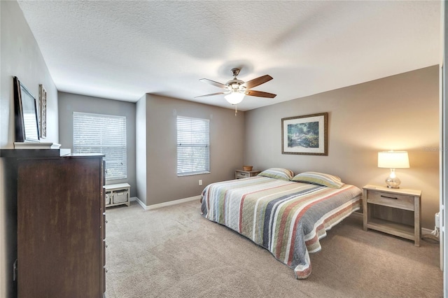 carpeted bedroom featuring a textured ceiling and ceiling fan