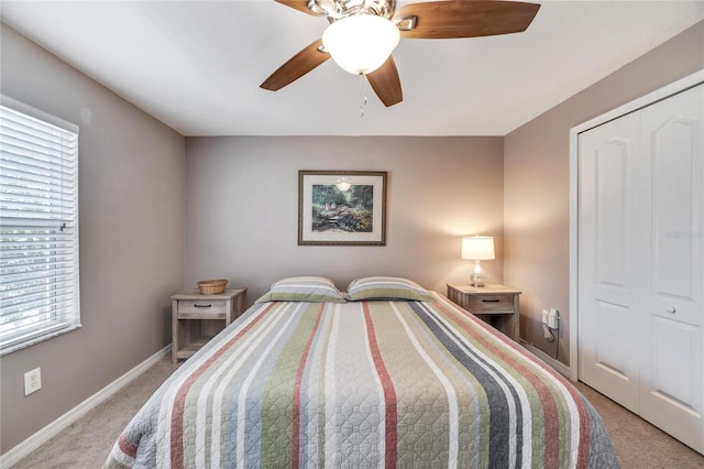 carpeted bedroom featuring multiple windows, ceiling fan, and a closet