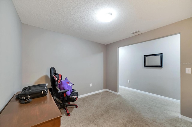 office area featuring light carpet and a textured ceiling