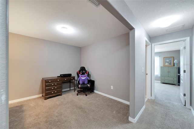 carpeted office space featuring a textured ceiling