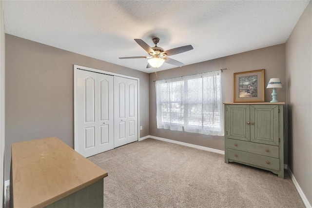 carpeted bedroom featuring ceiling fan, a closet, and a textured ceiling