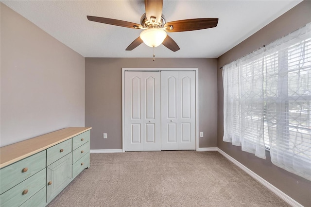 unfurnished bedroom with a closet, ceiling fan, and light colored carpet