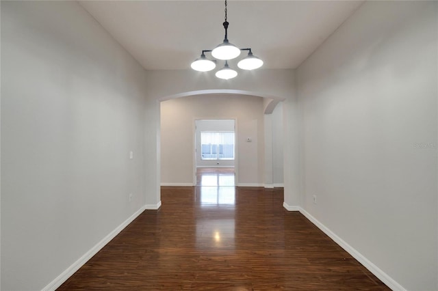 unfurnished dining area with dark wood-type flooring and a chandelier