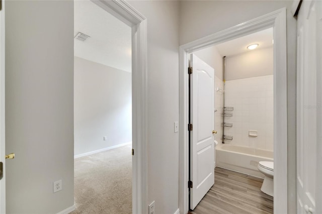 bathroom with tiled shower / bath combo and toilet