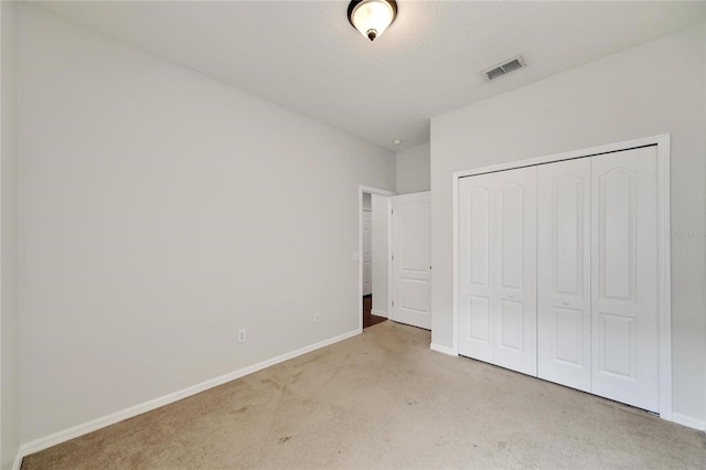 unfurnished bedroom featuring carpet flooring and a closet