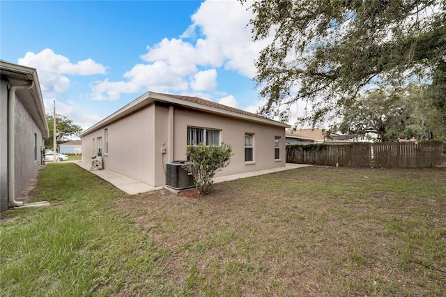 back of property featuring a yard and cooling unit