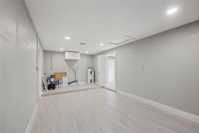 basement with electric water heater and light wood-type flooring