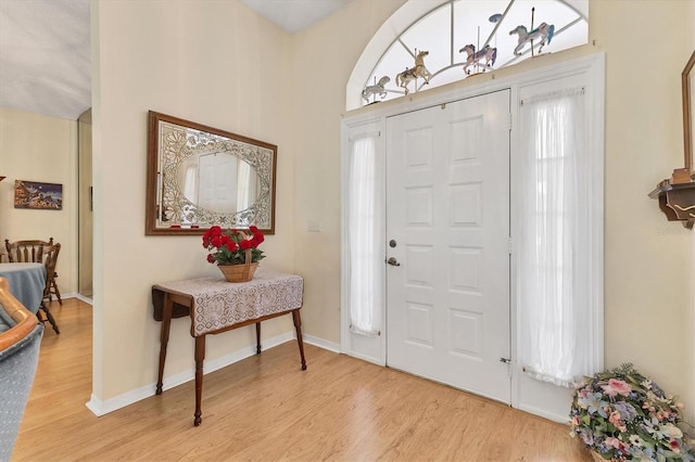 foyer with light wood-style floors and baseboards