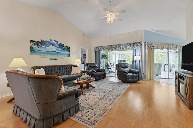 living area featuring light wood-style floors, ceiling fan, high vaulted ceiling, and baseboards