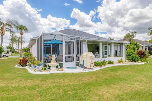 rear view of property with a sunroom and a lawn