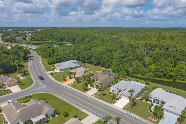 drone / aerial view featuring a residential view, a water view, and a forest view