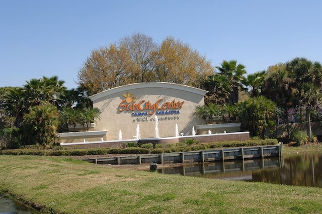 community / neighborhood sign featuring a yard and a water view