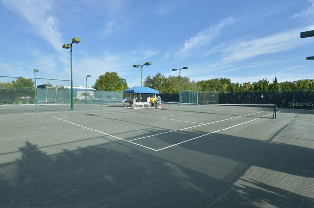 view of tennis court featuring fence