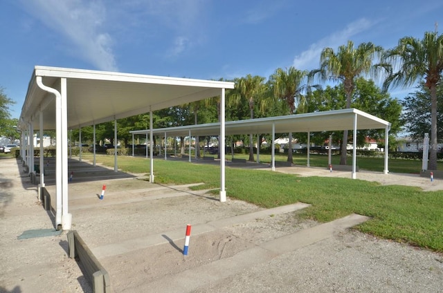 view of property's community with a carport and a lawn