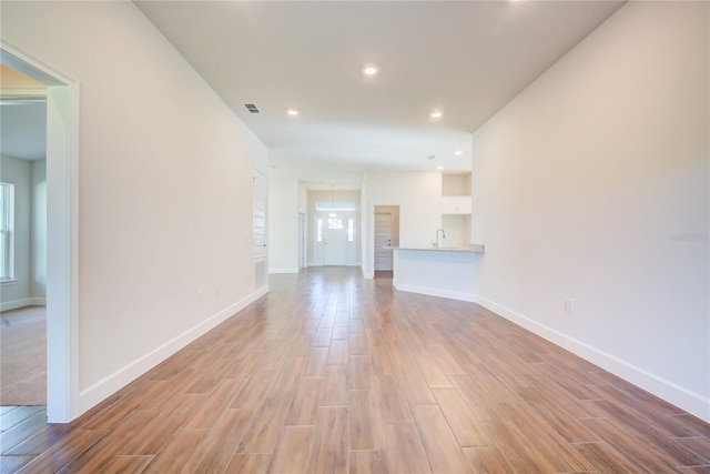 unfurnished living room with light wood-type flooring and sink