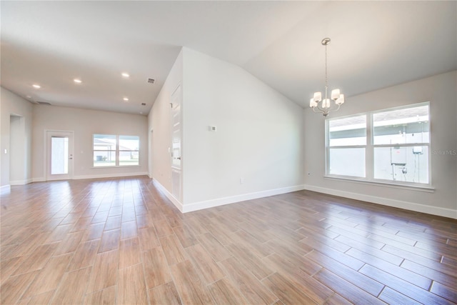 unfurnished room with lofted ceiling and an inviting chandelier