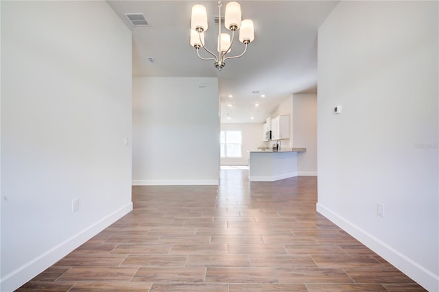 spare room with a notable chandelier