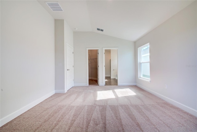 carpeted empty room with lofted ceiling