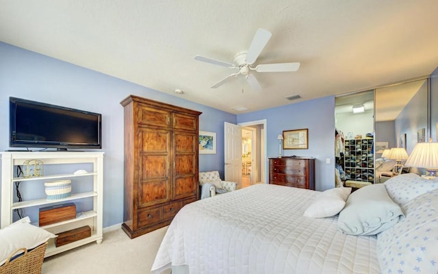 carpeted bedroom with ceiling fan and a closet