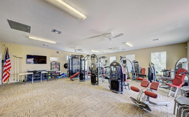 gym featuring a textured ceiling and ceiling fan